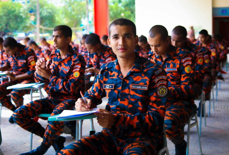 some students in red and black uniform sitting down