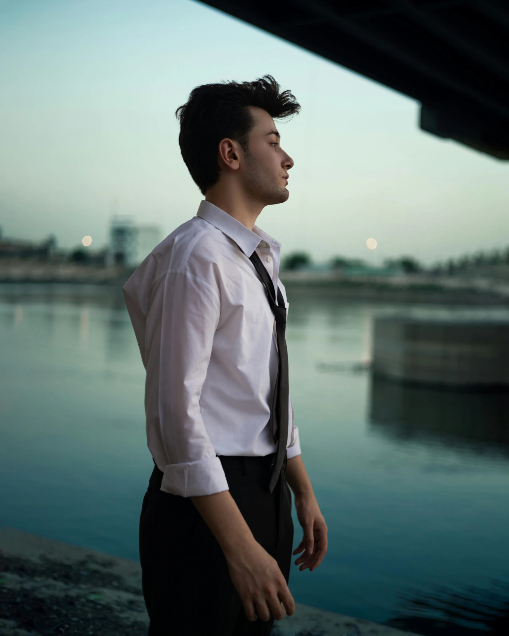 a man that is standing on a bridge with a tie on