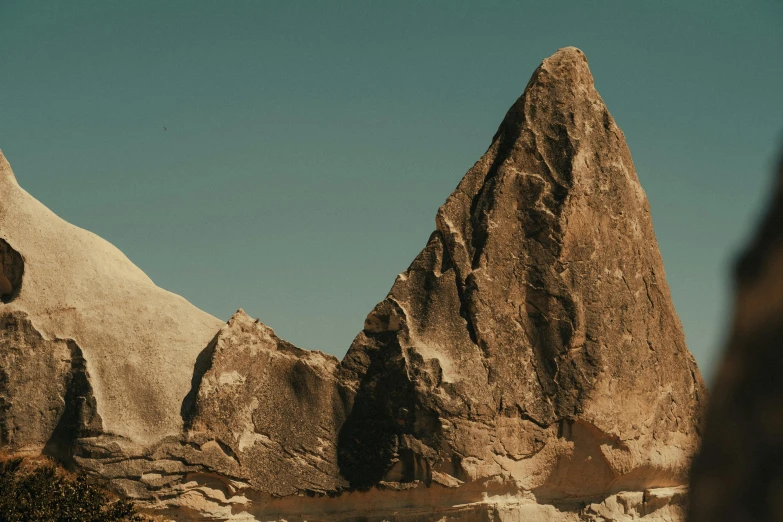 two large rocks in front of trees and a blue sky