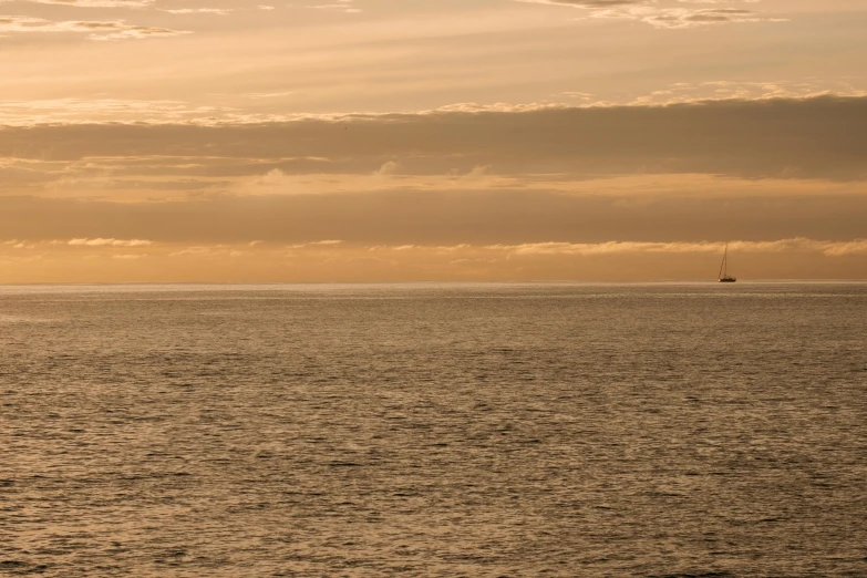 the view of an ocean with a sail boat out in the distance