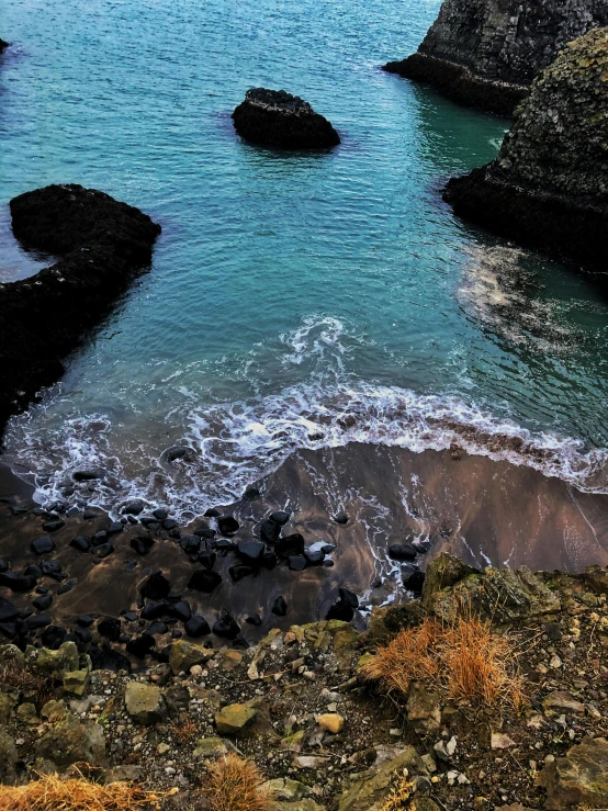 a body of water next to a rocky shore