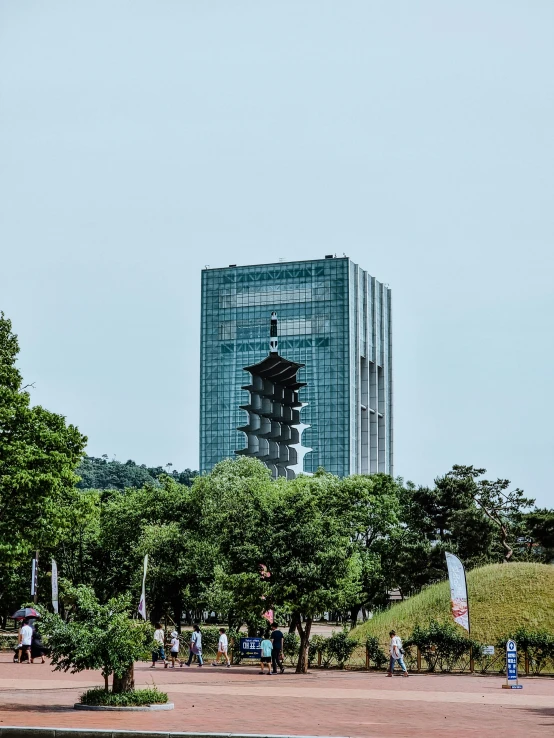 people walk in an open area in front of a tall building