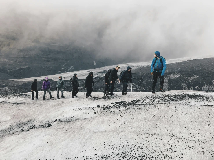 a group of people are walking on top of a snowy mountain