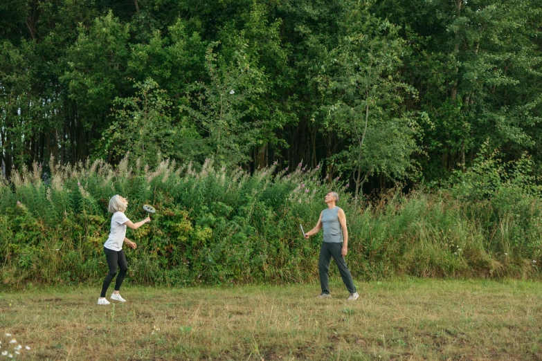 two people in the middle of a field holding a frisbee