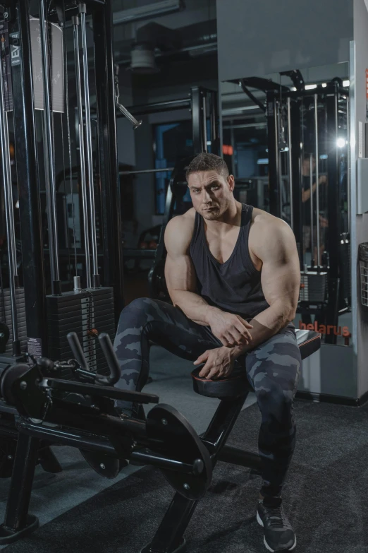 a man sitting on top of a gym bench