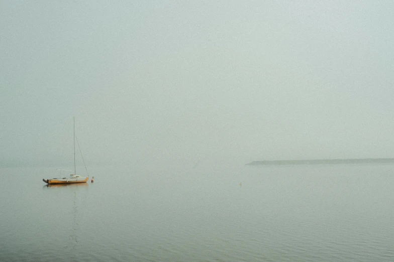 boat floating on water with fog surrounding it