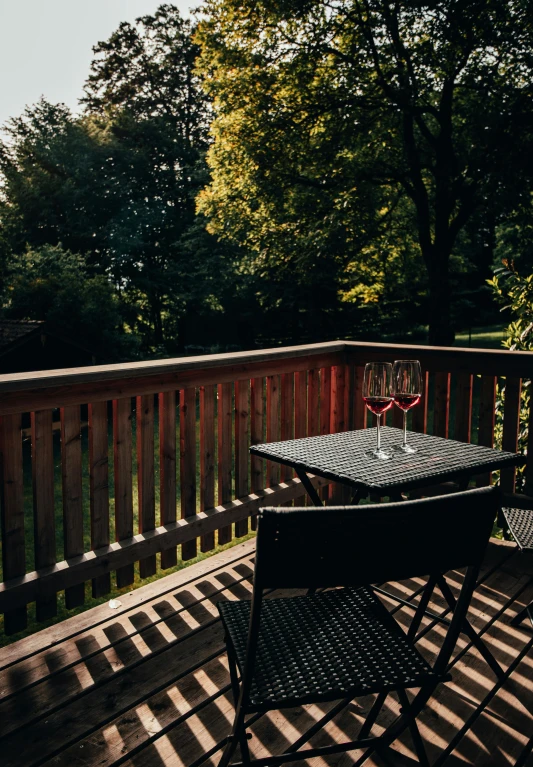 some chairs are on a deck outside next to trees