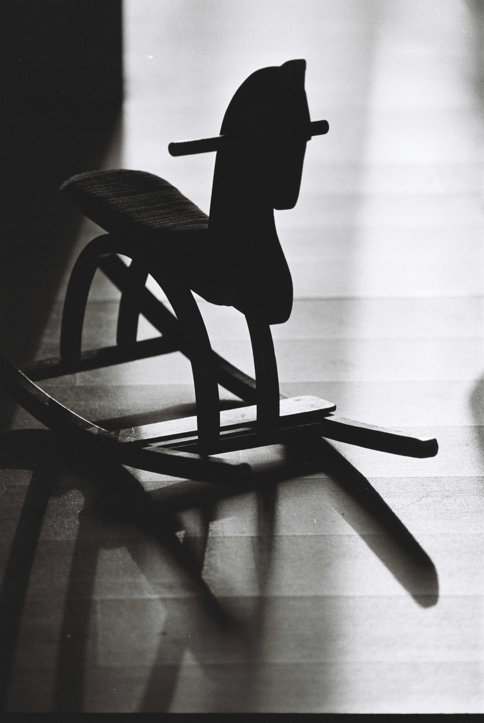 black and white image of rocking horse made out of wood