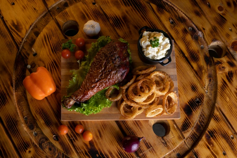 a plate with ribs, onion rings and salad