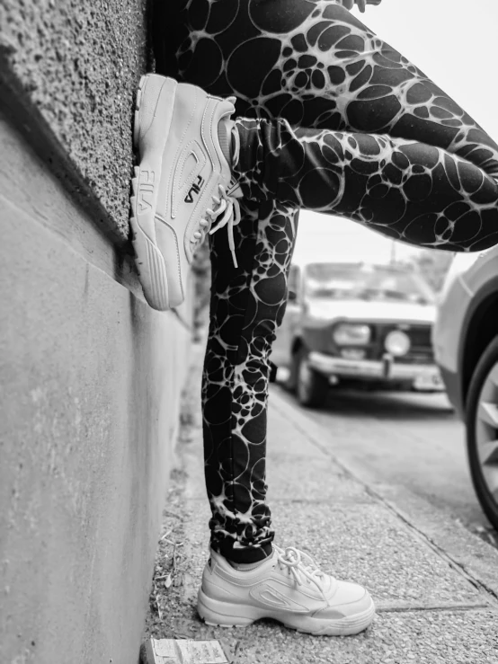 woman's legs sticking up against the wall and wearing patterned leggings