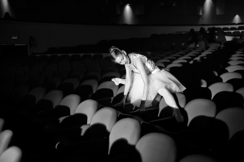 the dancer is in the middle of a set of chairs