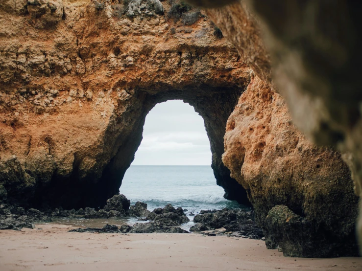 an open window is shown on a rocky beach