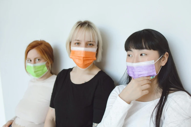 a group of women wearing face masks are posed together