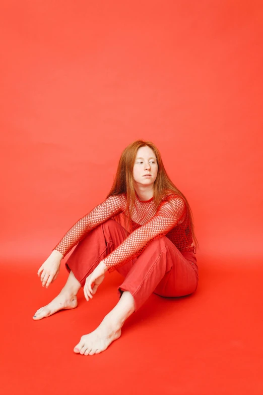 a woman sitting on the floor with her hands on her knees