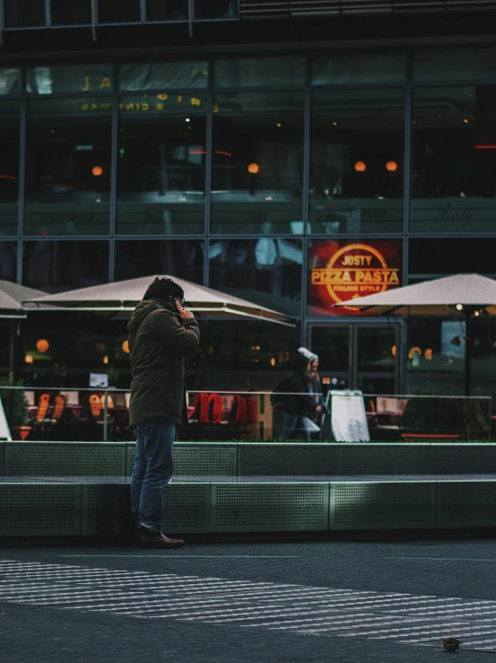 a man standing on a street corner in front of an asian restaurant