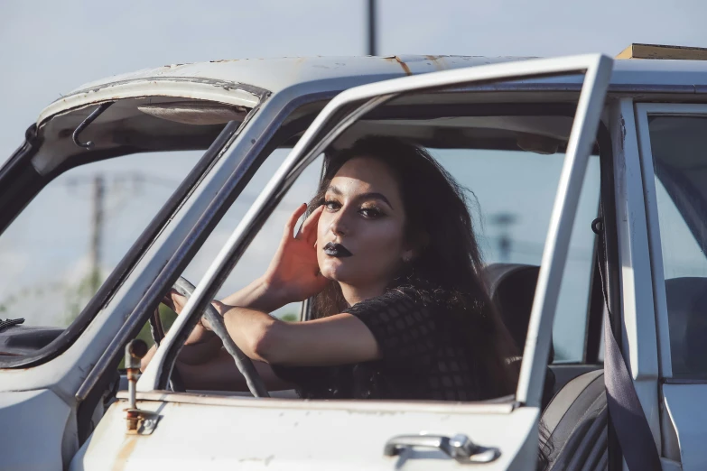 a woman leaning on a window sitting in a white car