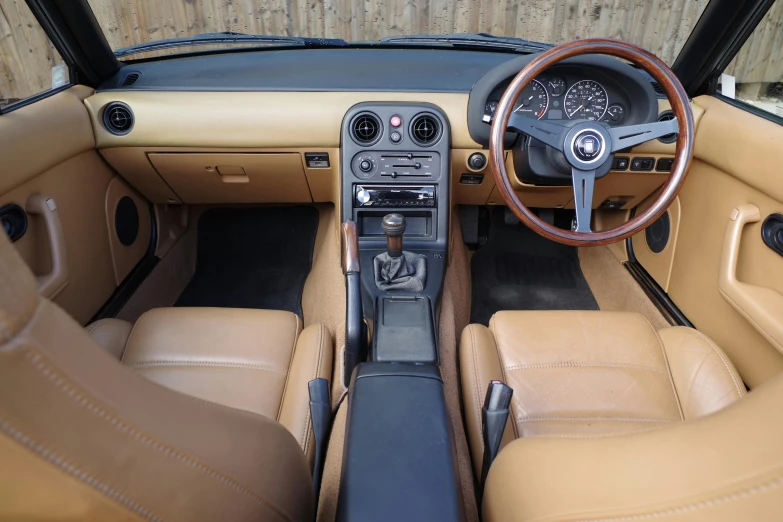 a dashboard view of a tan and brown sports car