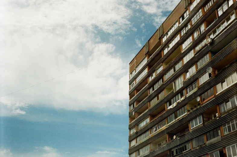 a very tall building with windows against a cloudy sky