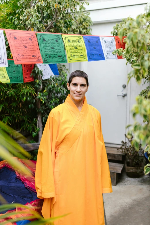 a person in a yellow raincoat standing next to a bush