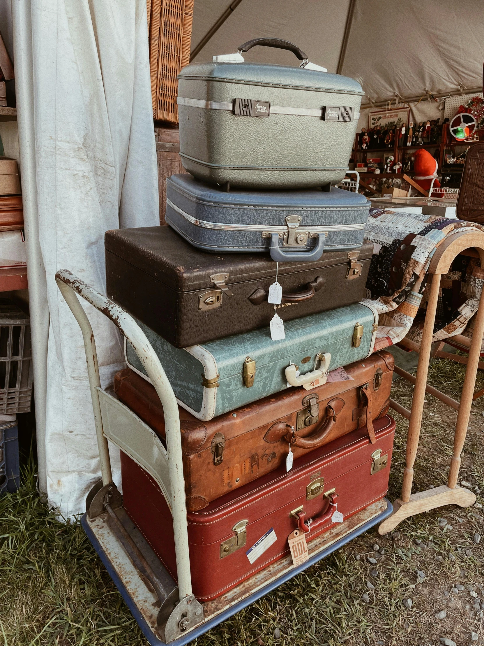 a pile of old luggage sitting outside a tent