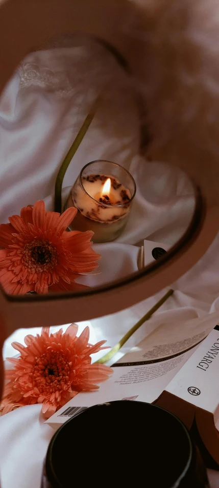 an upclose view of a table containing a candle and some flowers