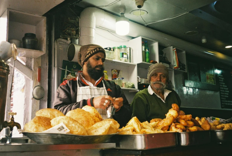 two men standing at a counter in a food restaurant