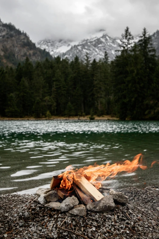 a fire in the ground near a lake