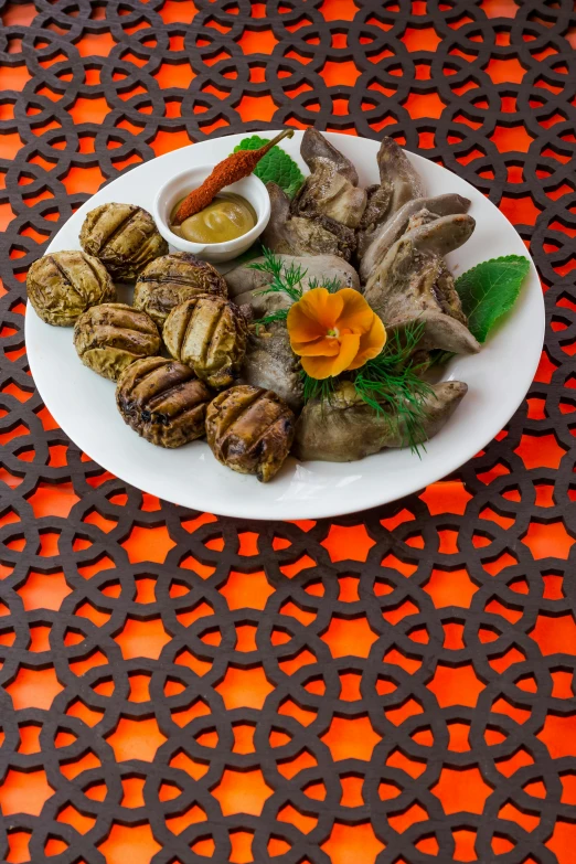 white plate on an orange and brown table with sauce