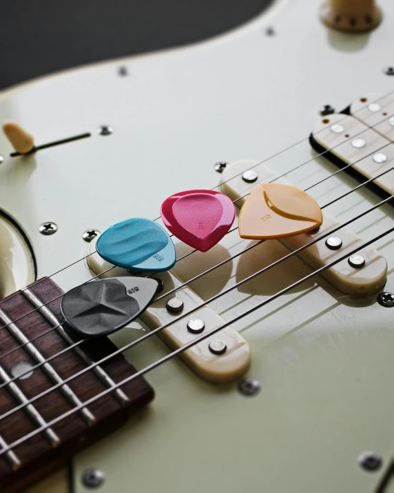 three small heart shaped ons attached to an electric guitar body