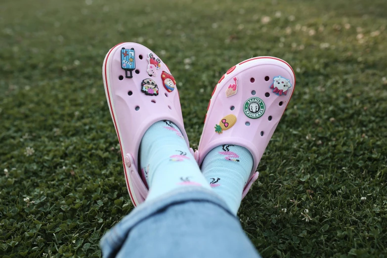 a person in blue pants with pink shoes standing on the grass