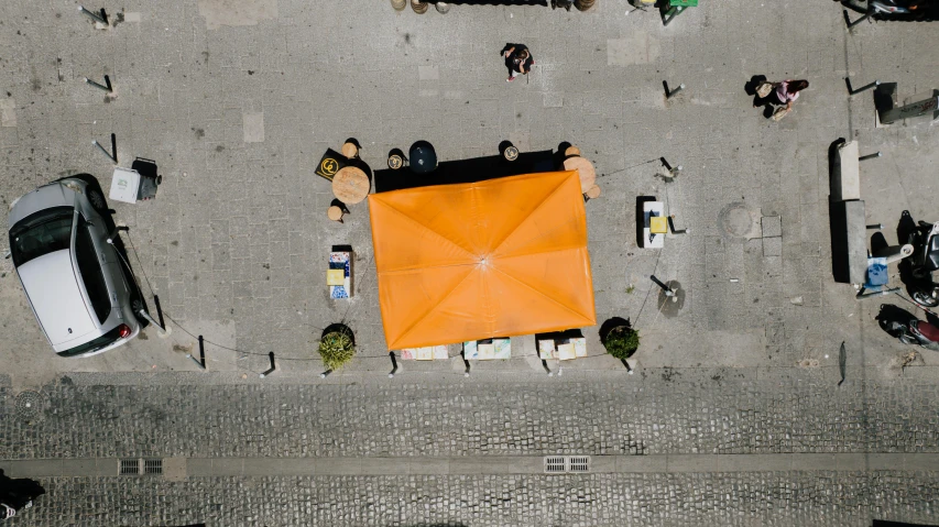 an overhead view of an umbrella surrounded by parked cars