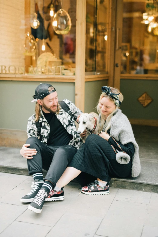 a couple holding a dog sitting next to each other