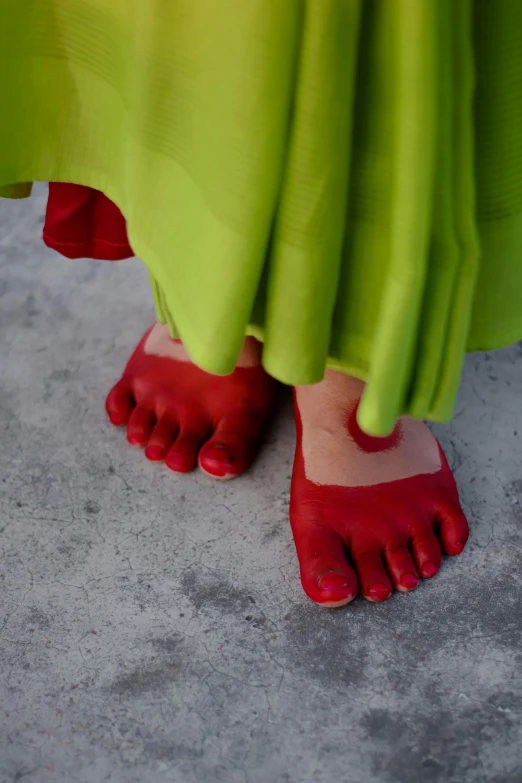 a persons feet in red and green heels