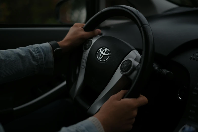 a person's hands on the steering wheel of a car