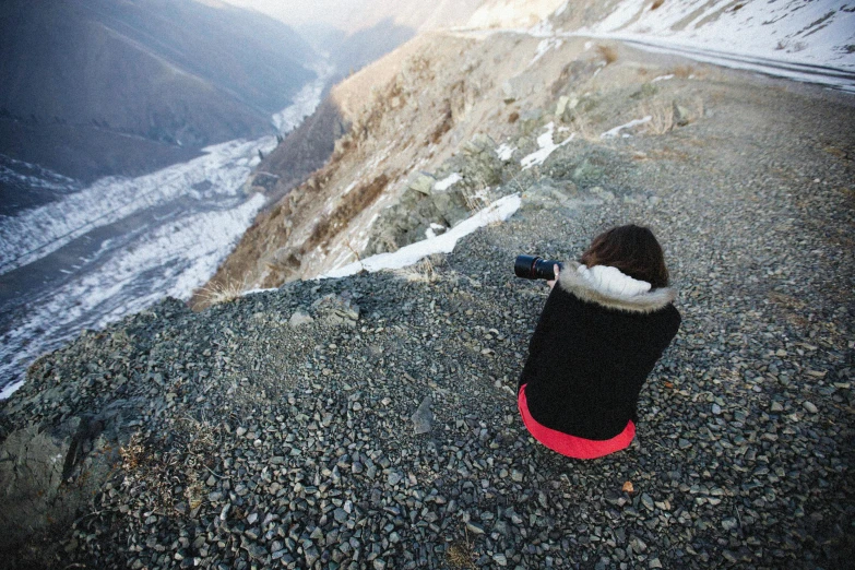 the person is sitting on the top of a mountain