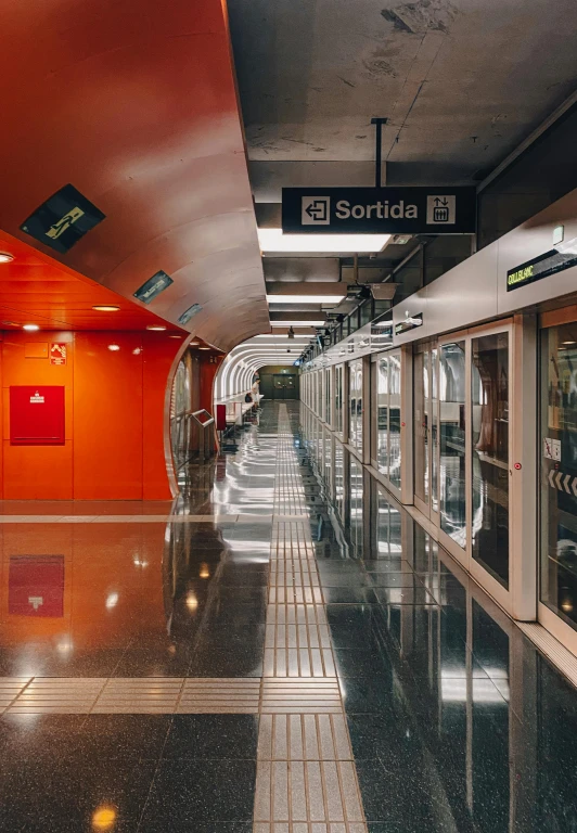 a train station with one person waiting on the subway