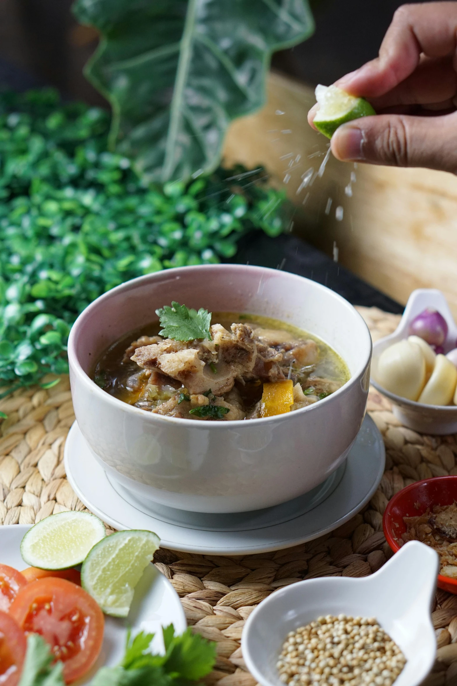 a white bowl of soup on a woven place mat