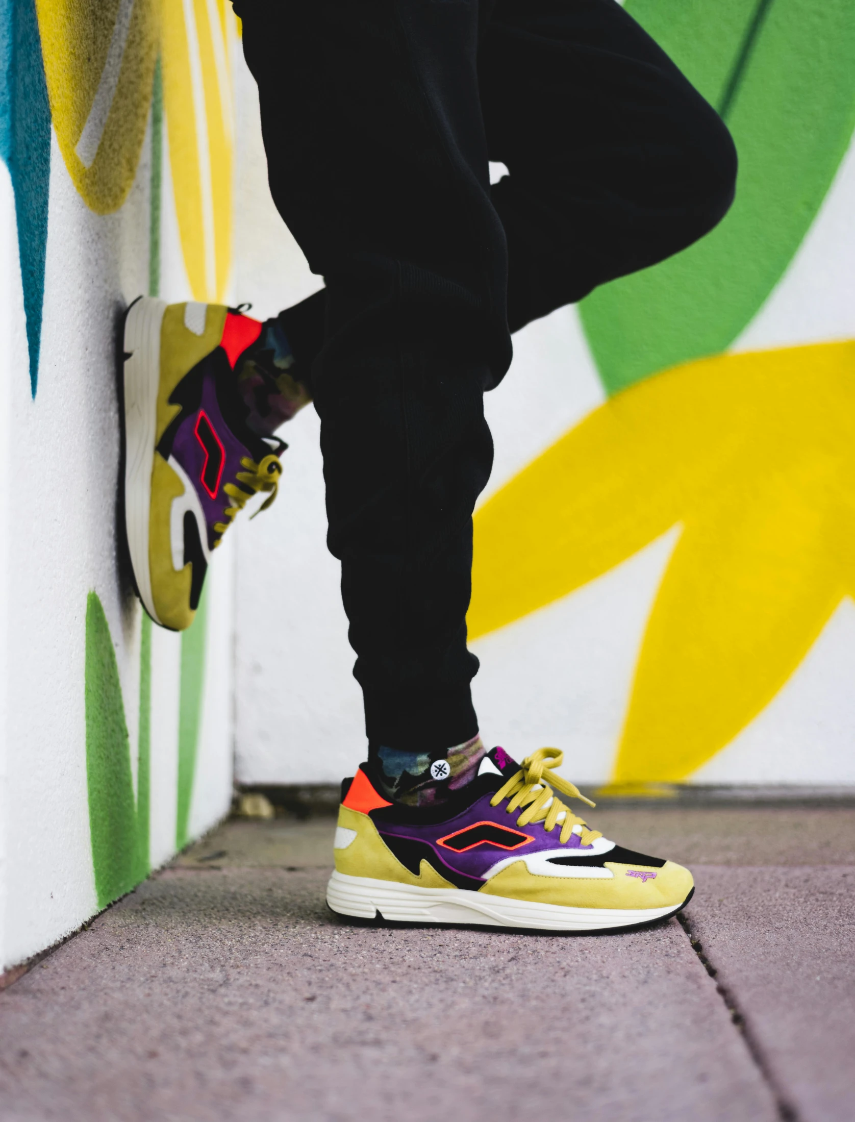 a man's leg and shoes standing on a cement floor