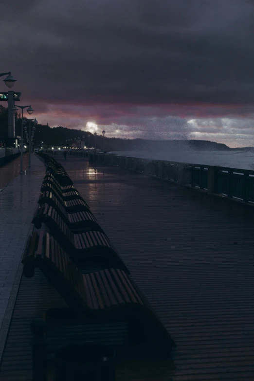 two benches in front of the sea in the rain