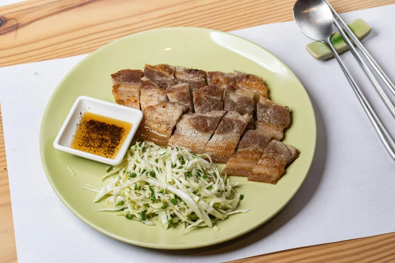 a plate topped with food next to chopsticks and rice