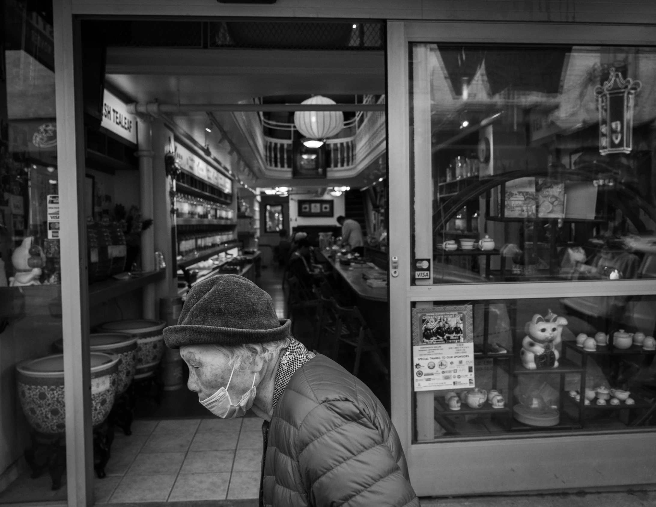 a woman looks through a store window while looking in