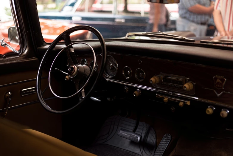 old cars inside a building with people looking in