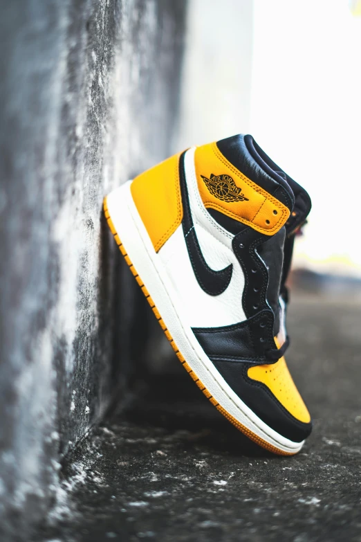 black and yellow shoe on concrete floor against concrete wall