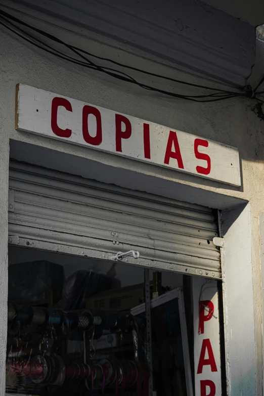 an open storefront has red letters that says copias