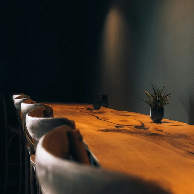 a wooden table topped with lots of chairs