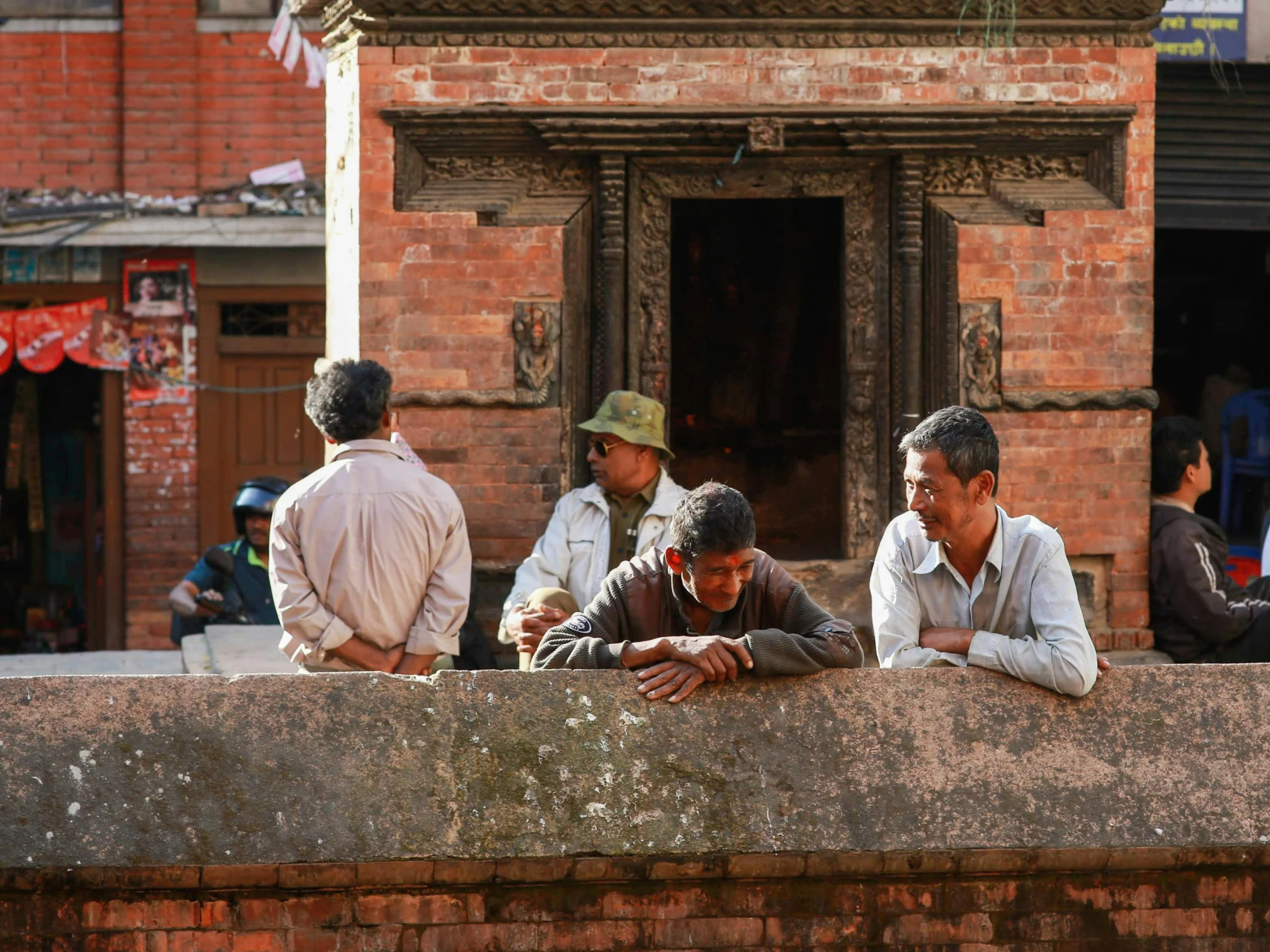 a bunch of people that are leaning on a stone