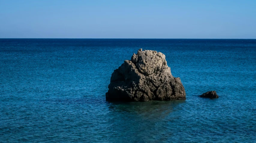 a small rock is on the ocean surface