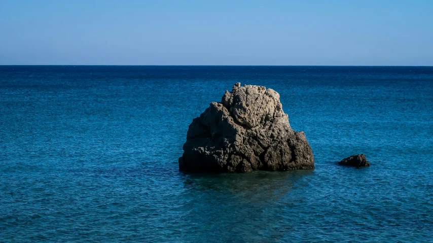 a small rock is on the ocean surface