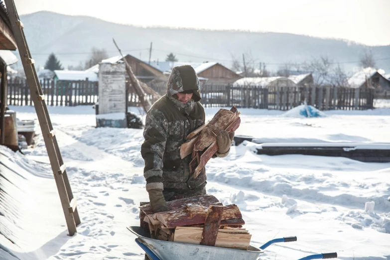 a man carrying snowboards in the snowy landscape