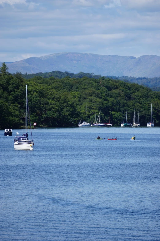 several boats are floating on the large lake